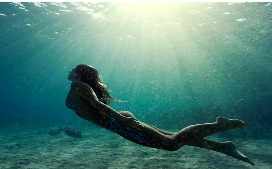 Девушка плывет под водой