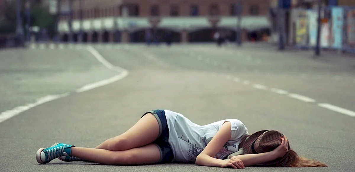 Девушка лежит на дороге