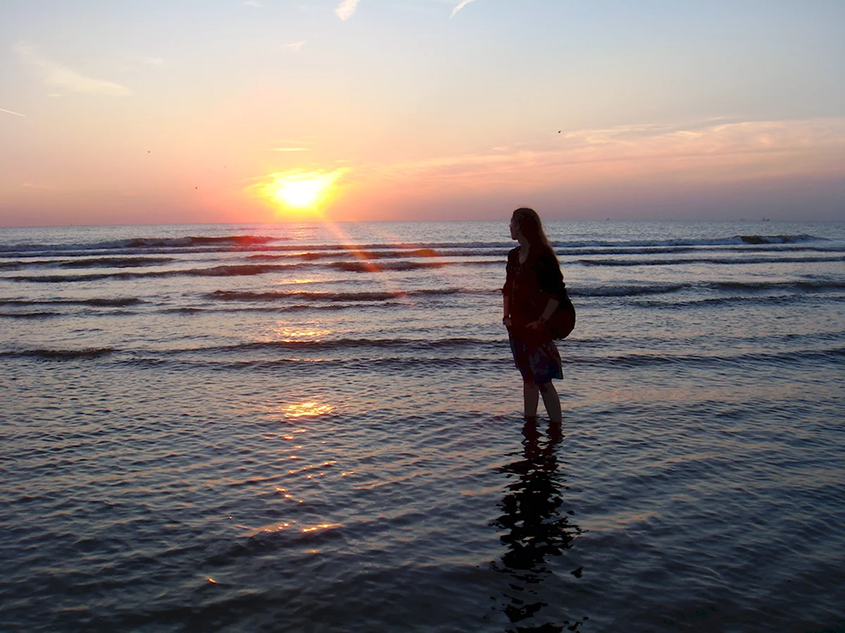 Девушка на берегу моря на закате