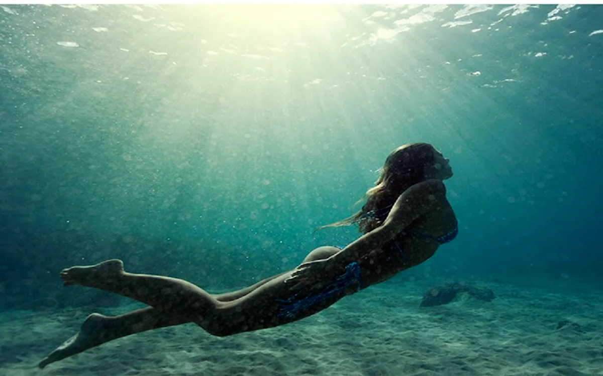 Девушка плывет под водой
