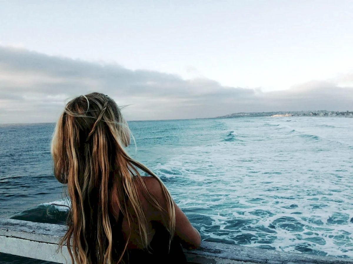Девушка с длинными волосами у моря